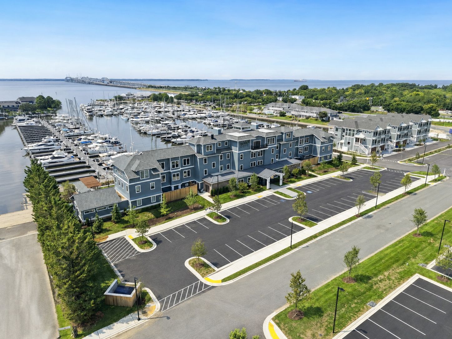 A marina with boats, a parking lot, and a building with a blue facade.