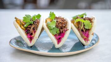 Tres tacos sobre un plato de cerámica.