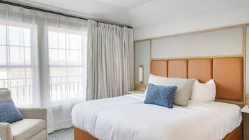 Une chambre d’hôtel avec un grand lit, une chaise, une table de chevet et une fenêtre avec des rideaux.