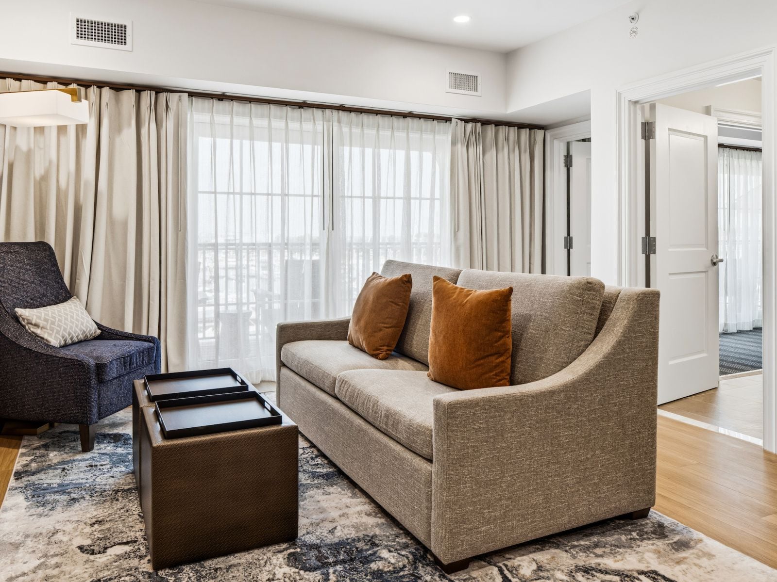 A modern living room with a sofa, armchair, and a coffee table.