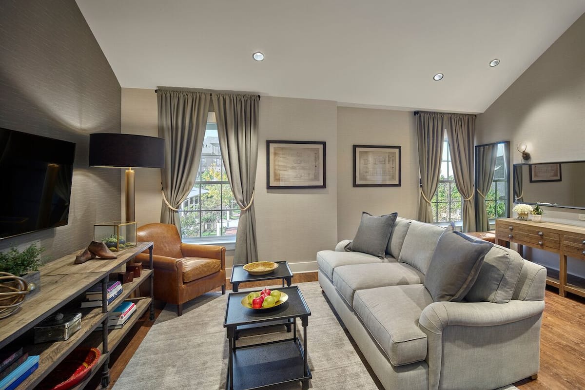 A modern living room with a sofa, armchair, coffee table, and TV.