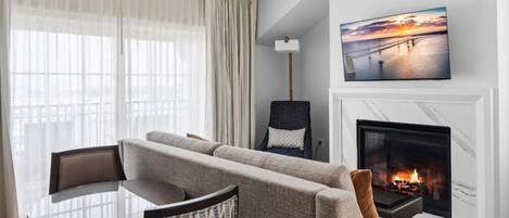 A living room with a sofa, a table, and a fireplace.