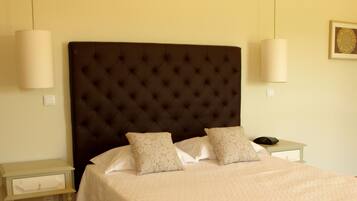 A neatly made bed with a tufted headboard, two bedside tables, and a wall-mounted light fixture.