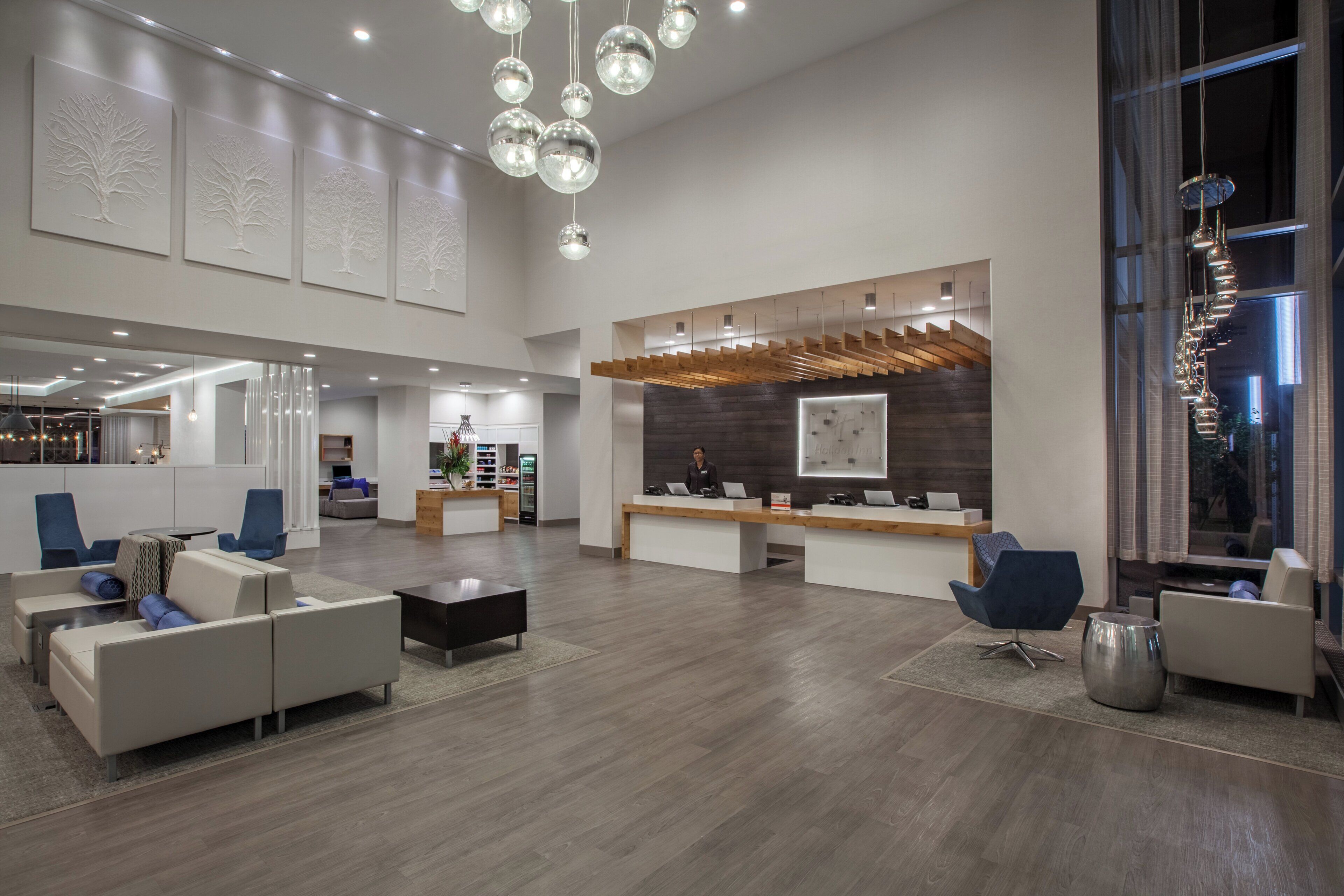 A spacious lobby with a reception desk, seating area, and a large window.