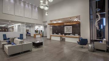 A spacious lobby with a reception desk, seating area, and a large window.