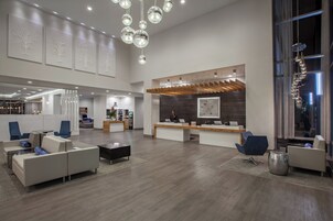 A spacious lobby with a reception desk, seating area, and a large window.