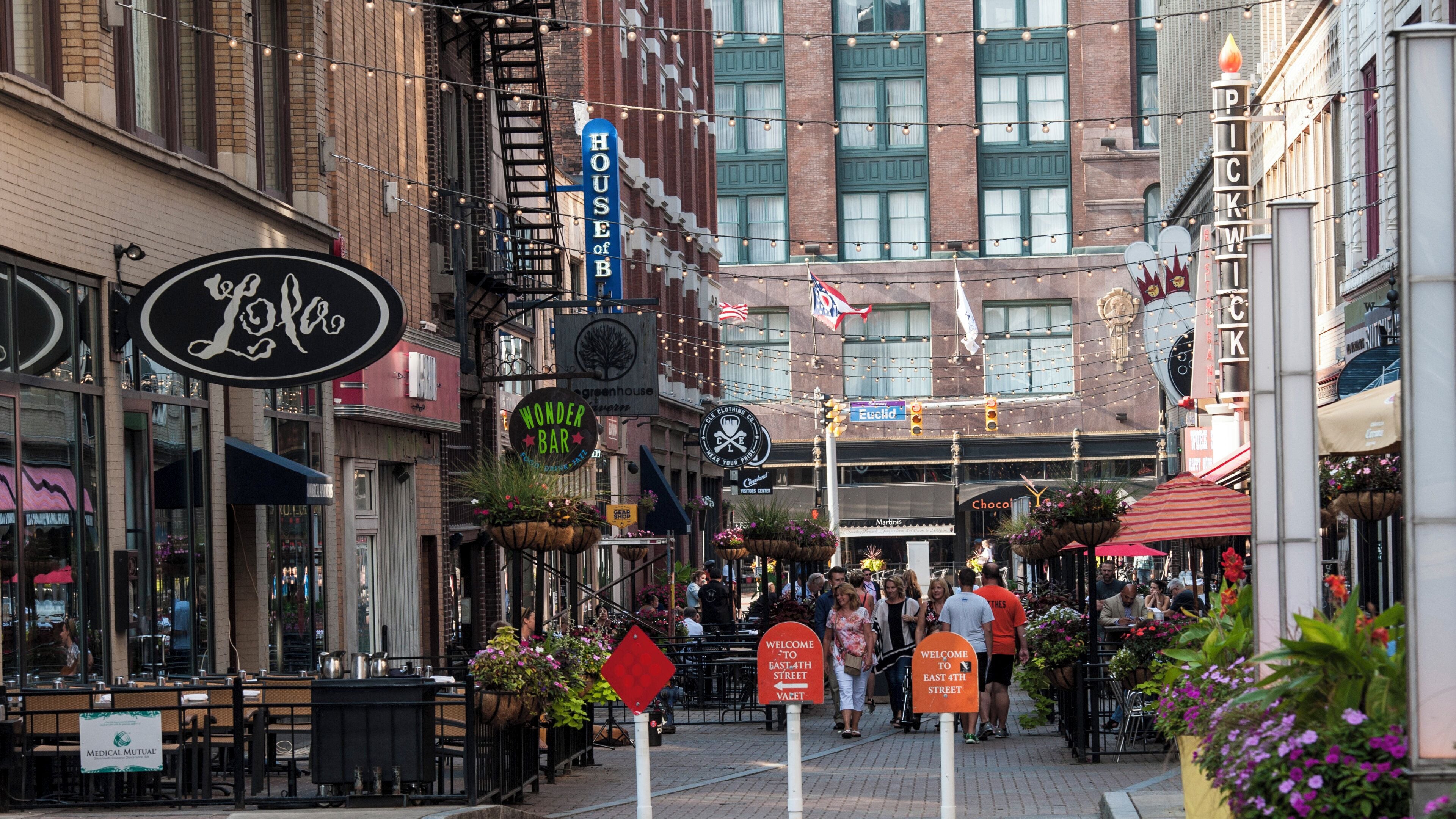 Une rue bordée de divers commerces, avec une enseigne « House of B » sur le côté gauche.