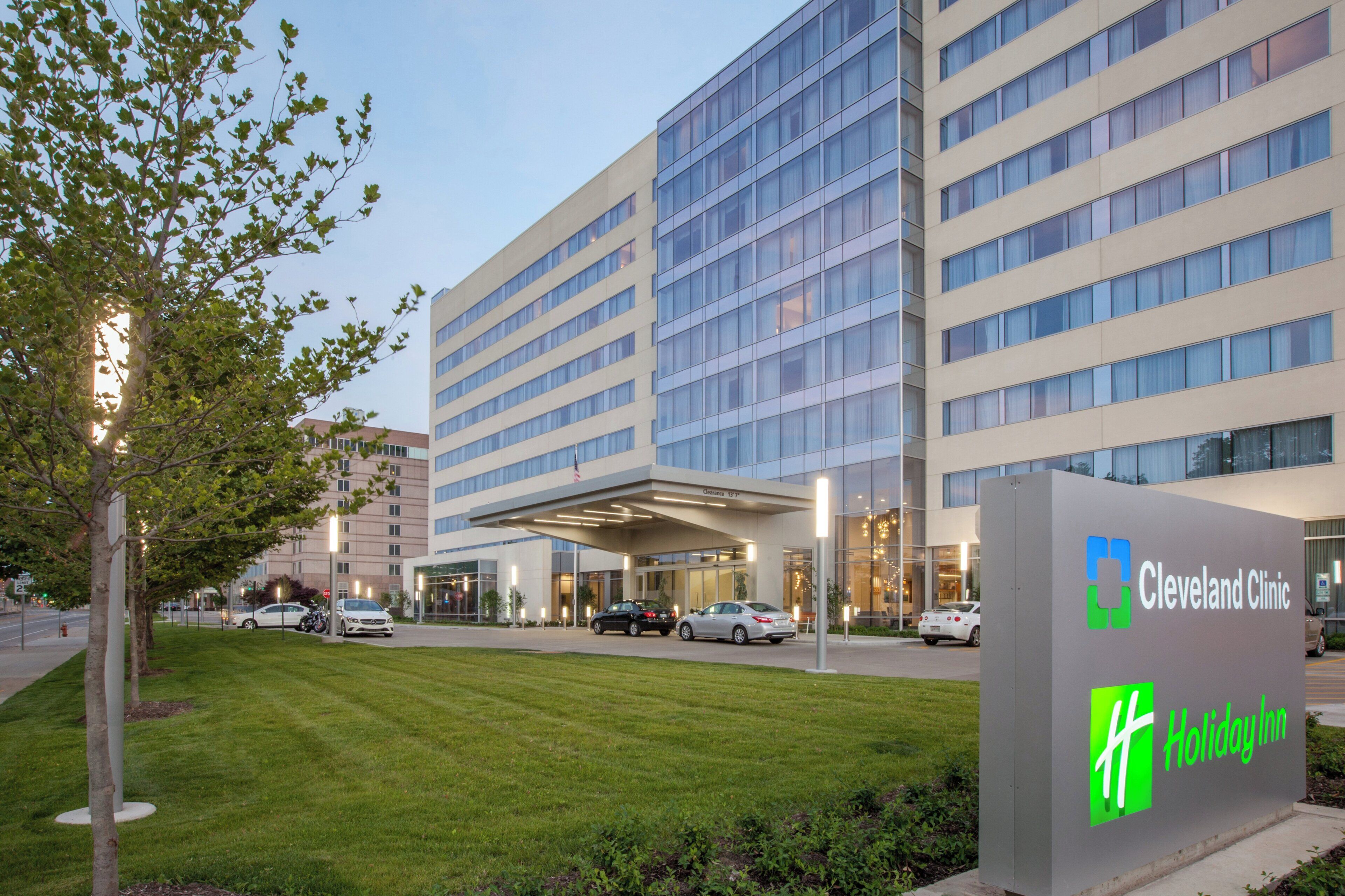 Un bâtiment de la Cleveland Clinic, sur lequel on peut voir une enseigne Holiday Inn, est entouré d’une pelouse bien entretenue et de voitures garées.