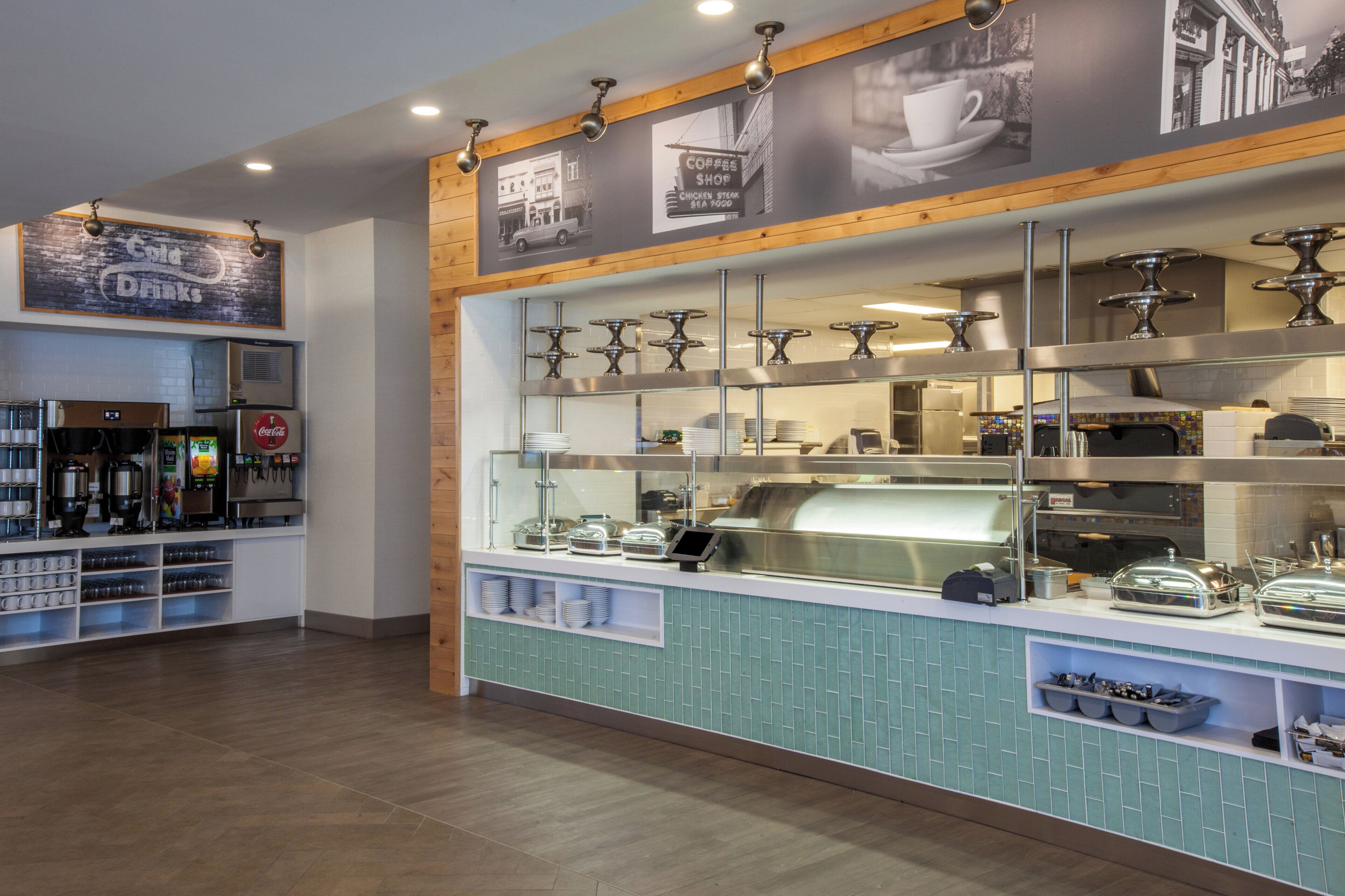 A coffee shop with a counter, coffee machines, and a menu board.