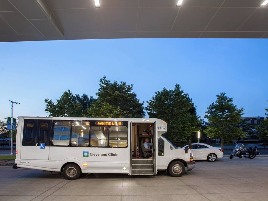 Un autobús blanco con la señalización 'Cleveland Clinic' y 'White Line' estacionado en una gasolinera.
