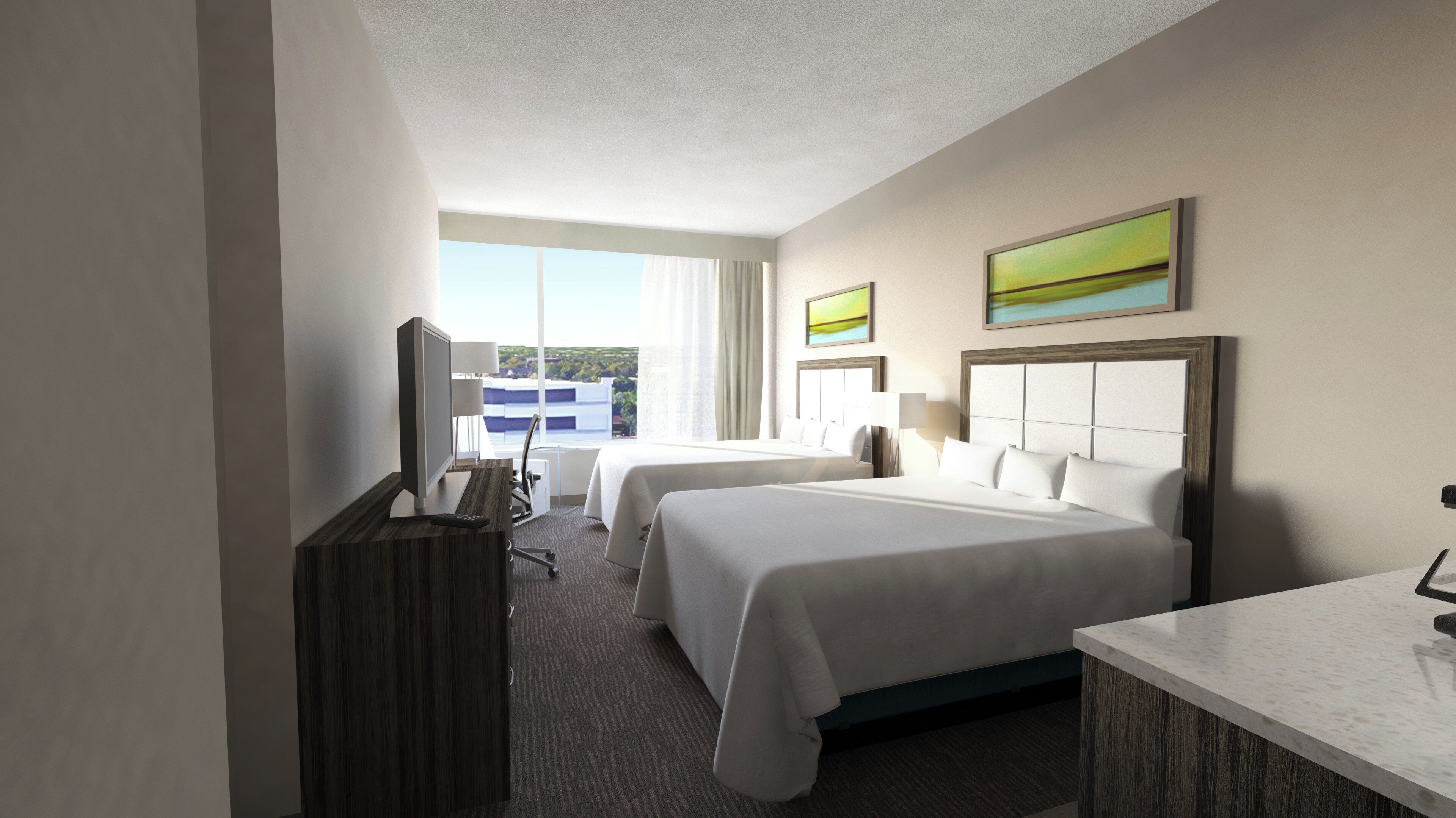 A hotel room with two beds, a desk, a TV, and a view of the outdoors.