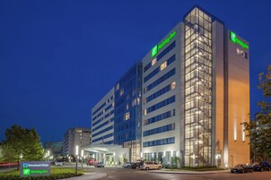 Un hotel Holiday Inn con diseño moderno, que cuenta con fachada de vidrio y varios pisos.