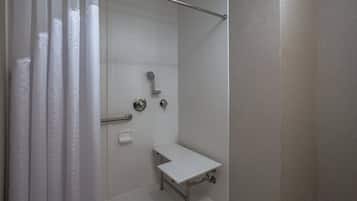 A shower with a handheld showerhead, a handheld showerhead, and a handheld showerhead.