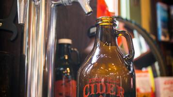 A copper tap and a glass jug with a label on a bar counter.
