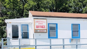 A white building with blue trim and a sign reading "Friendly Inn Office Vacancy." - Friendly Inn Motel (Harrisburg)