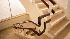 A staircase with wooden handrails and beige steps. - Granda Inn (Tuxtla Gutierrez)