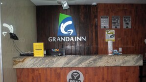 A hotel reception desk with a wooden finish, a WiFi symbol, and a logo for 'GRANDA INN'. - Granda Inn (Tuxtla Gutierrez)