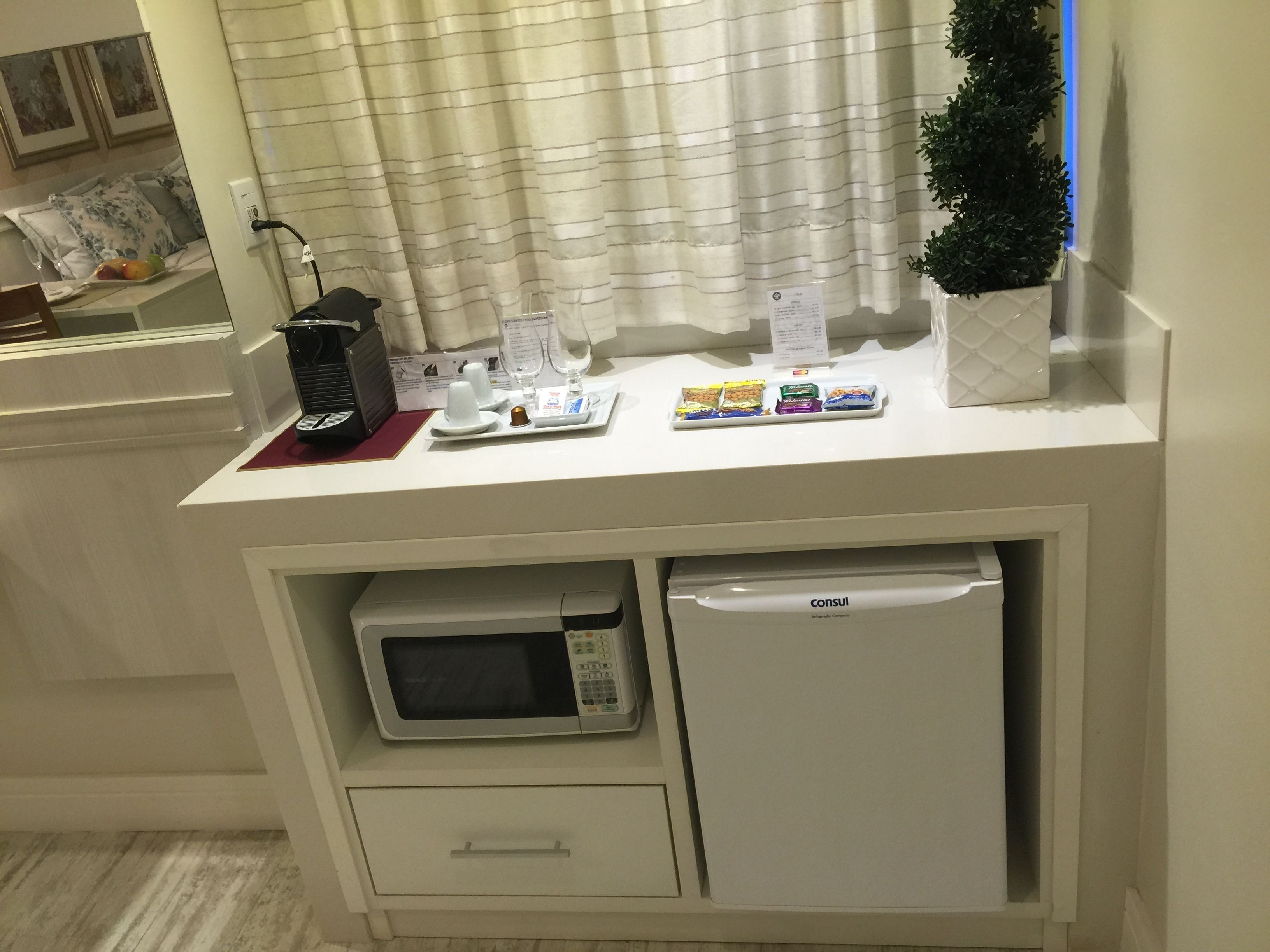 A kitchenette with a microwave, a coffee maker, and a small refrigerator.