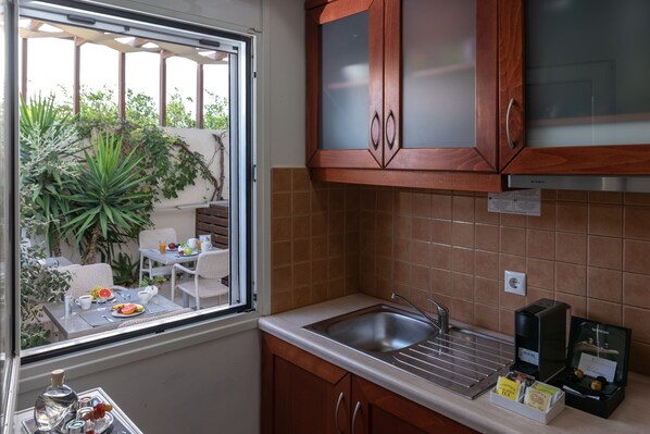 Una cocina pequeña con ventana, un lavabo y una cafetera.