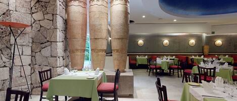 Un restaurant aux murs en pierre, avec de nombreuses tables et des chaises.
