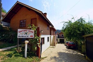 Una casa rústica amb un rètol que indica 'Cantinho Colibri Rua Netuno, 42'.