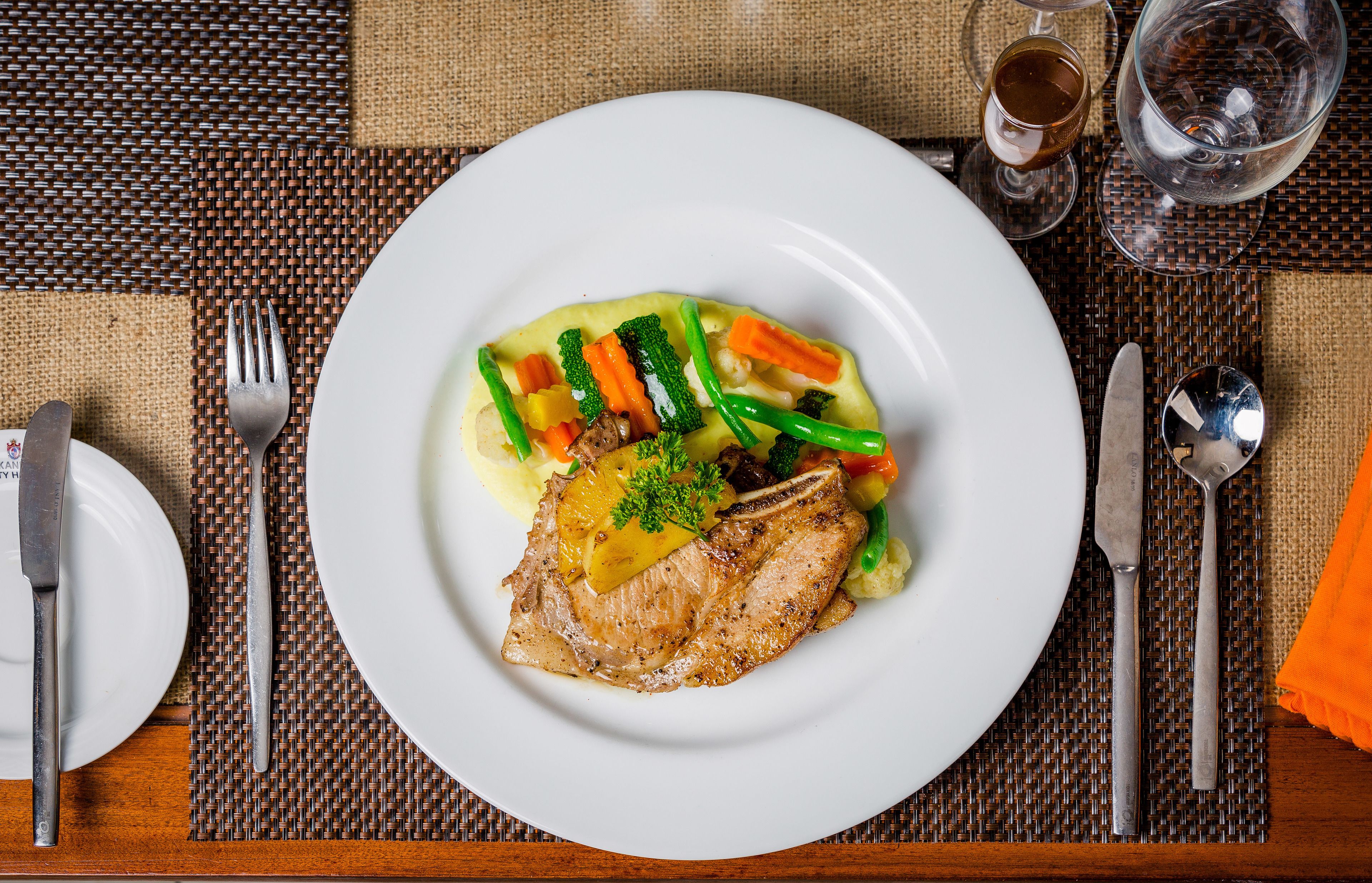 A plate of food with a piece of meat, vegetables, and sauce.