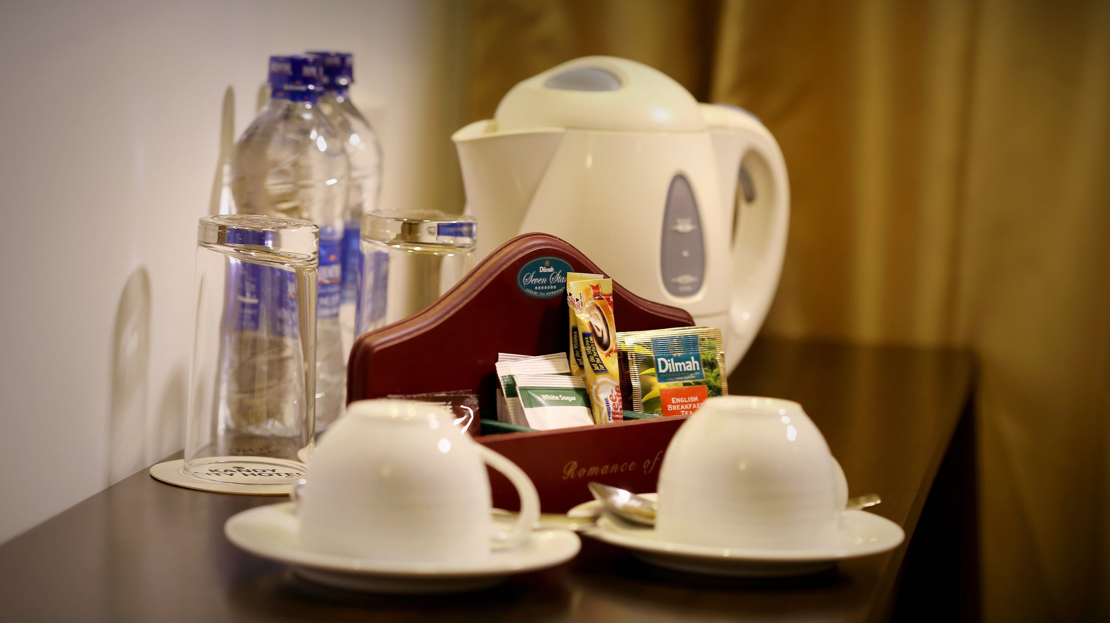 Une table dressée pour le petit-déjeuner, avec deux tasses blanches, une théière, une cafetière et divers éléments pour le petit-déjeuner.