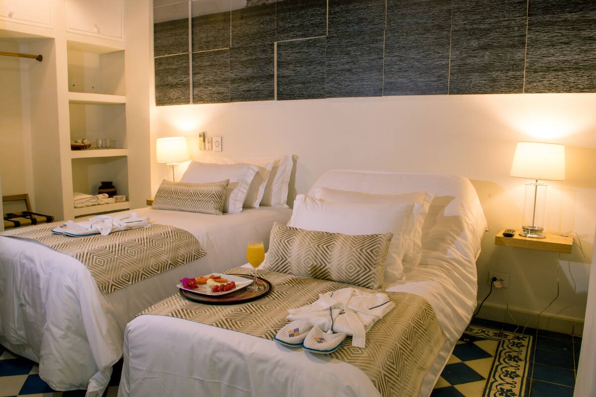 Une chambre d’hôtel avec deux lits, une salle de bain et un mini-bar.