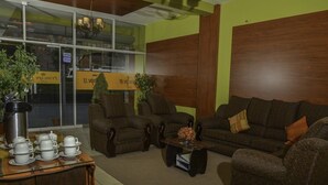 Una sala acogedora con dos sofás, una mesa de centro y una mesita auxiliar con juegos de té.