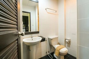 A bathroom with a white sink, toilet, and a mirror above the sink. - M Place Pattaya (Pattaya)