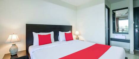 A hotel room with a large bed, two bedside tables, and a nightstand.