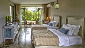 A hotel room with two beds, a desk, and a view of greenery through the glass door. - Reverie Siam Resort (Pai)