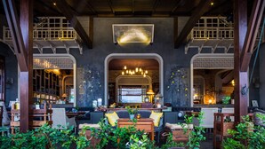 A spacious, well-lit interior with a central seating area, wooden beams, and a sign reading "Reverie Siam". - Reverie Siam Resort (Pai)