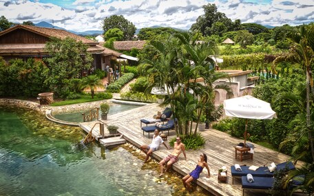 A resort with a pool, lounge chairs, and a wooden deck.