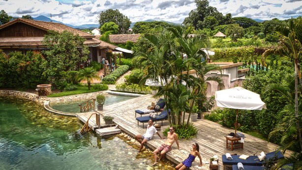 A resort with a pool, lounge chairs, and a wooden deck. - Reverie Siam Resort (Pai)