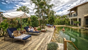 A poolside area with lounge chairs, a wooden deck, and a pool. - Reverie Siam Resort (Pai)