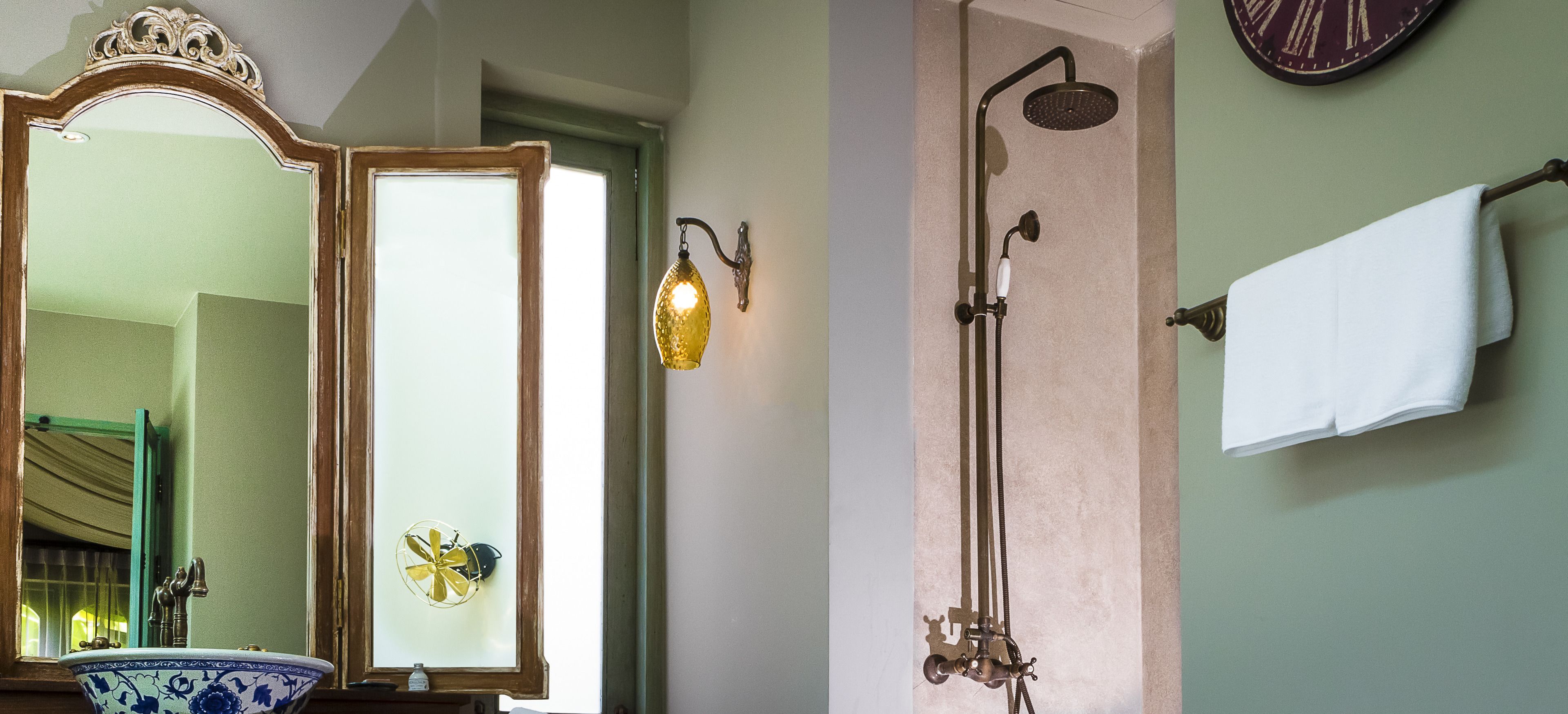 A bathroom with a mirror, a shower, and a towel rack.