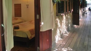 Un pasillo con pisos de madera y una cama con dosel en una habitación.