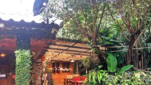 Un restaurante con interior de madera, una pizarra con el menú y diversas plantas.