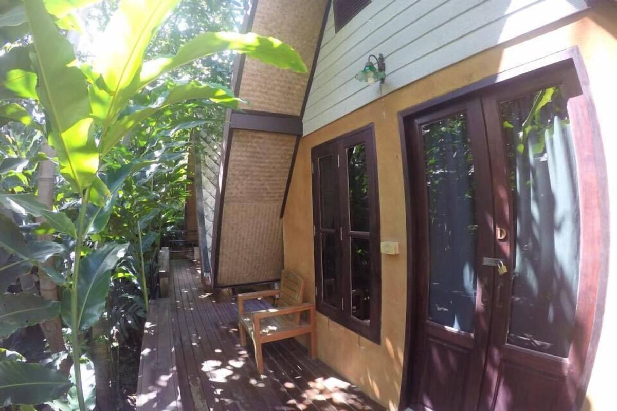 A wooden deck with a bench, a door, and a window.