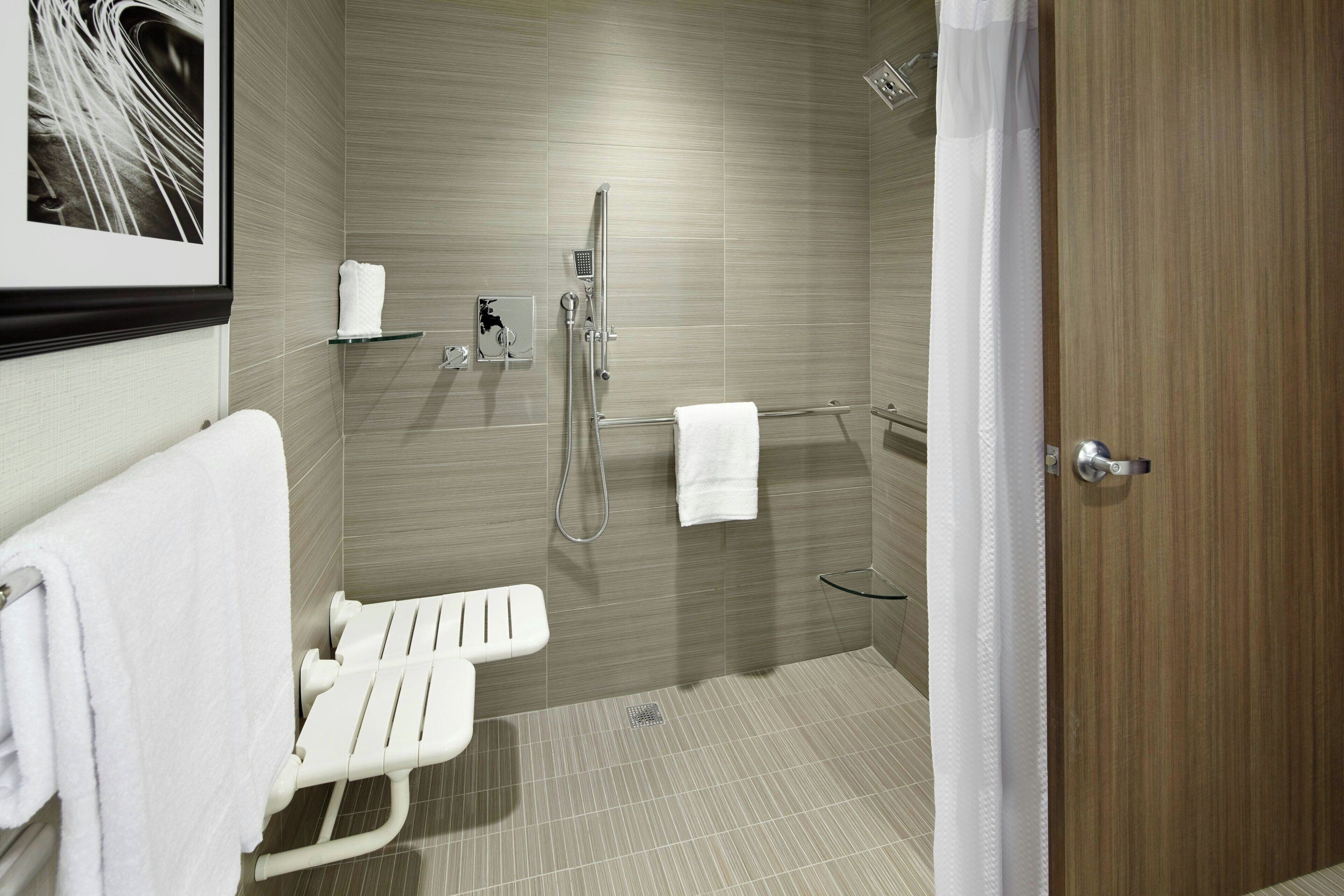 A modern bathroom with a shower, a toilet, and a hand dryer.