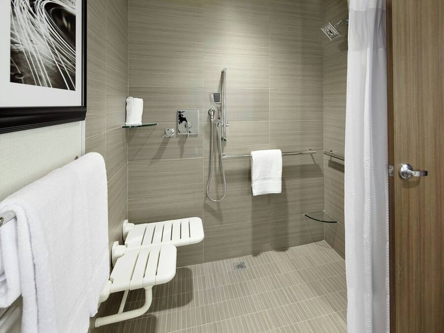 A modern bathroom with a shower, a toilet, and a hand dryer.