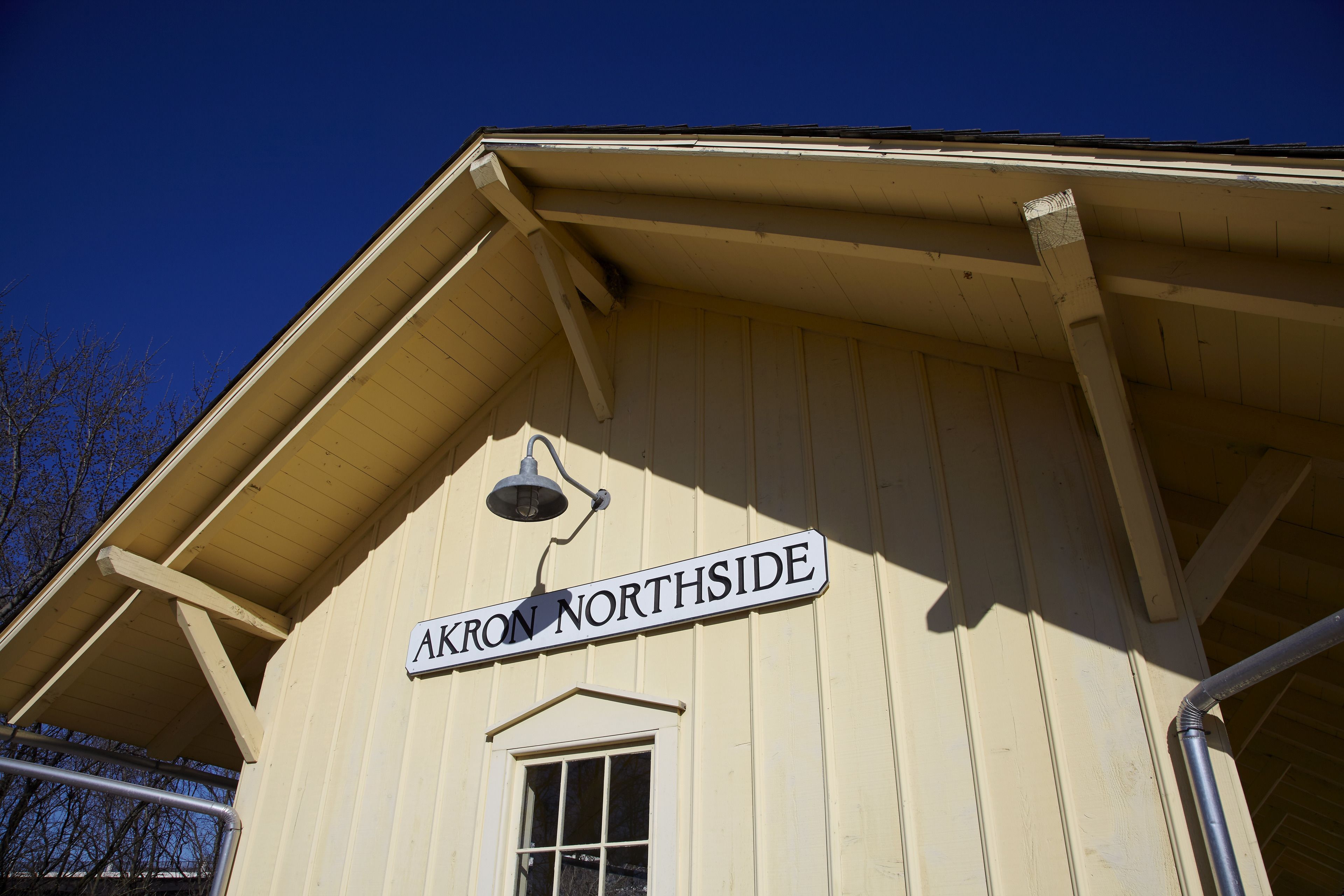 A building with a sign reading "AKRON NORTHSIDE" and a window below it.