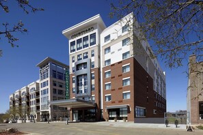 A multi-story hotel with a modern design, featuring a prominent 'Courtyard' sign, a covered entrance, and a brick facade. - Courtyard Akron Downtown (Akron)