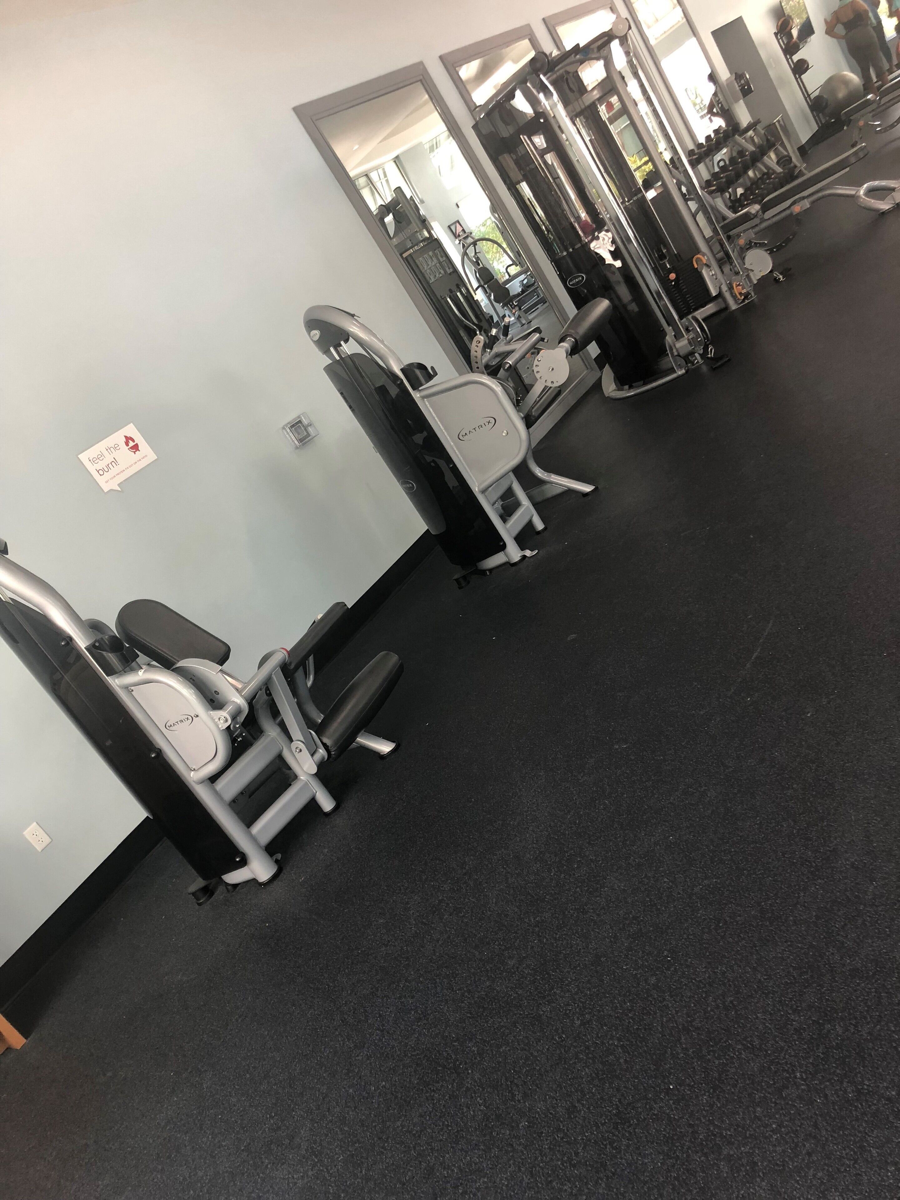 A gym with various exercise machines, including a leg press and a chest press.