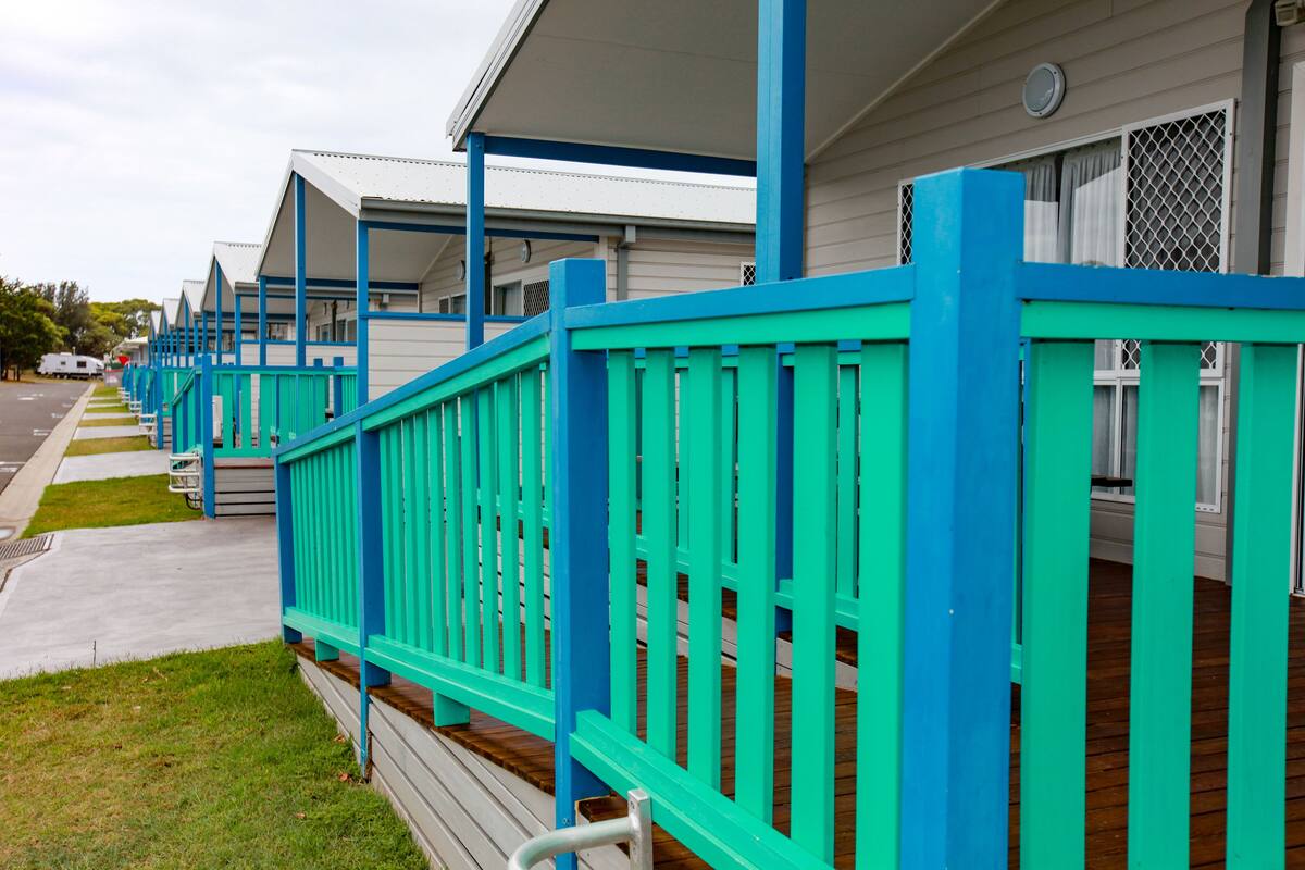 Filas de habitaciones de motel con barandillas azules y un corredor cubierto.