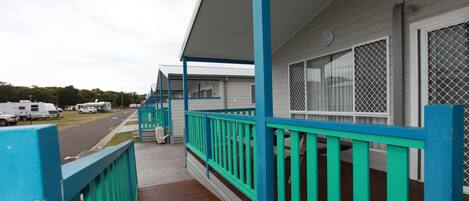 A motel with a wooden deck and turquoise railings.