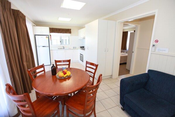 Un espacio habitable compacto con comedor, kitchenette y sofá.