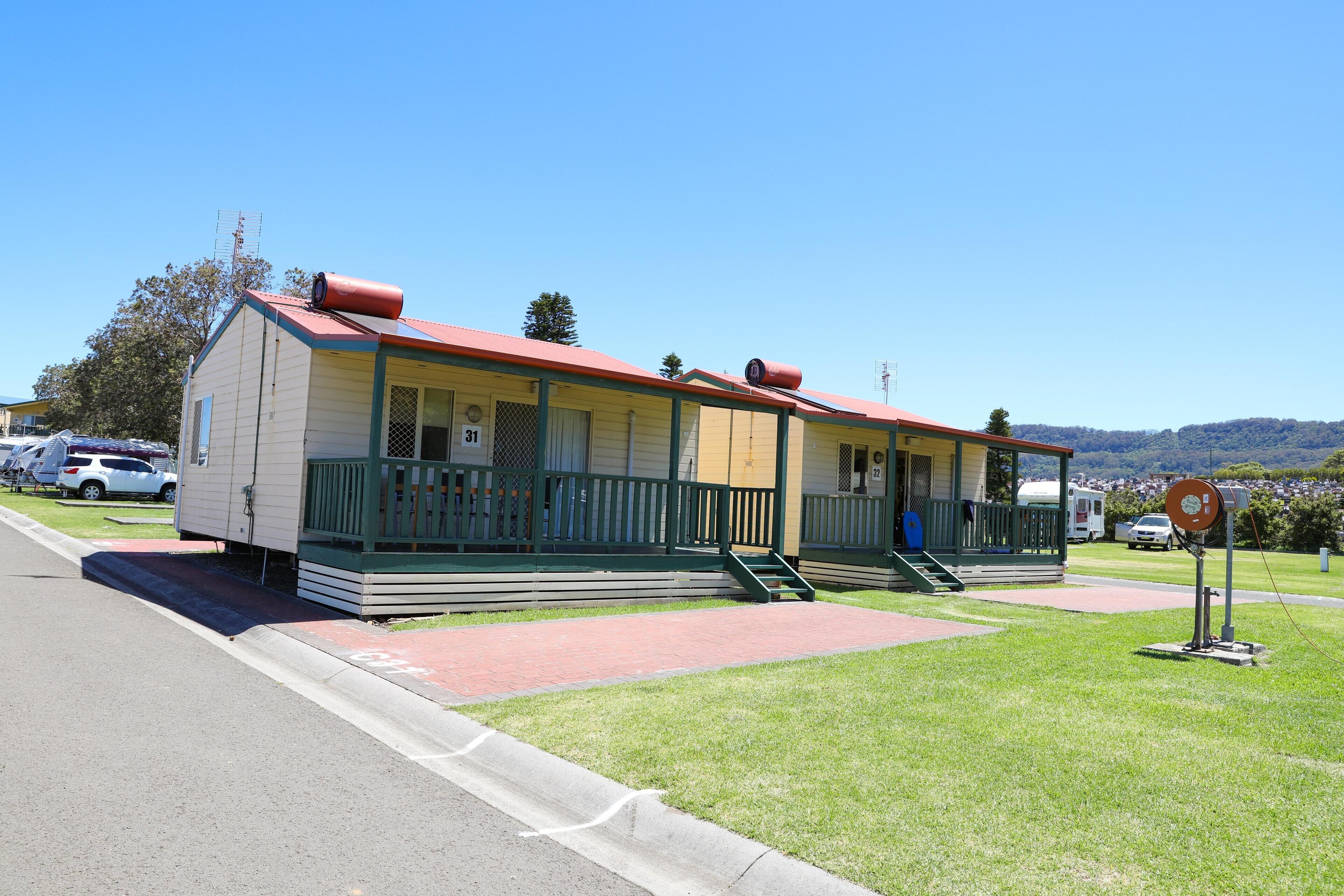 A motel with two-story buildings, a red roof, and a green porch.
