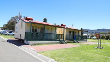 A motel with two-story buildings, a red roof, and a green porch.
